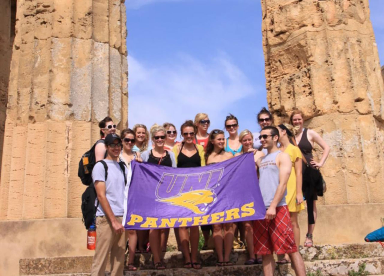 Students displaying UNI flag at the Capstone in Italy.