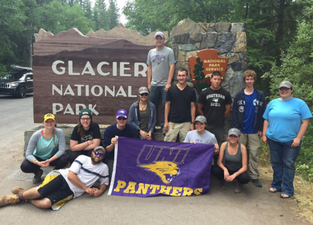 UNI students at the Glacier National Park displaying UNI flag.