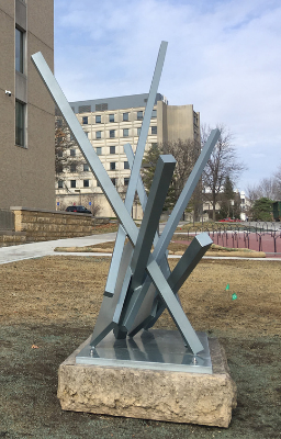 Beams stacked sculpture in a courtyard.