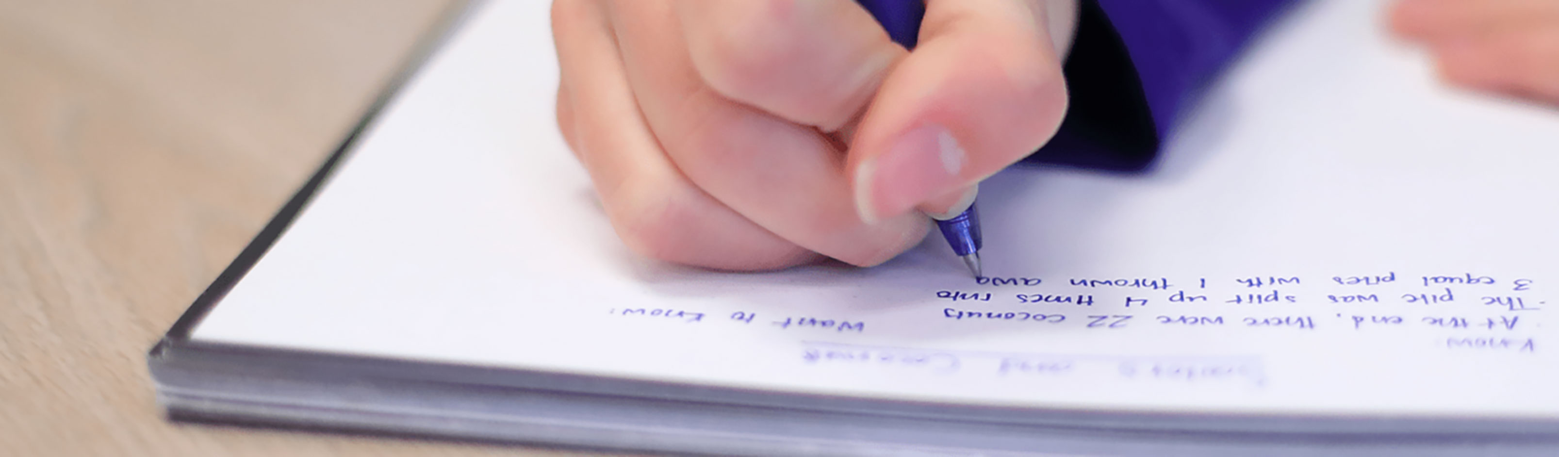 Closeup of student taking notes in a notebook.