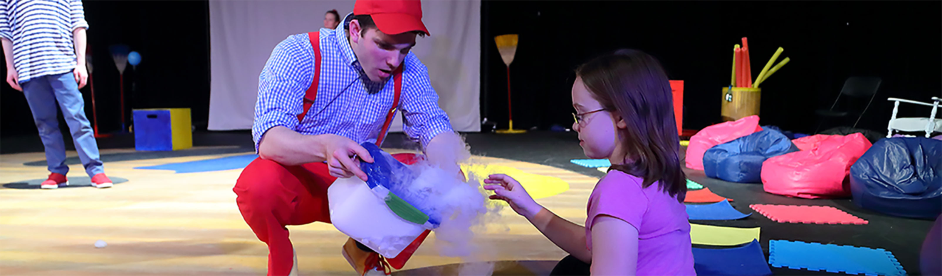 A student and a performer on stage during sensory demonstration.