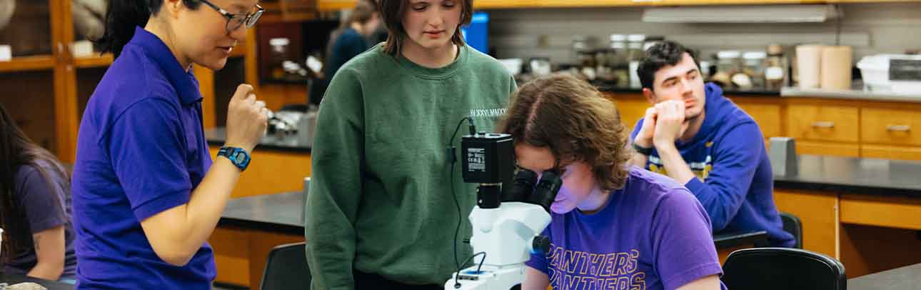 Student working with professor on project with microscope
