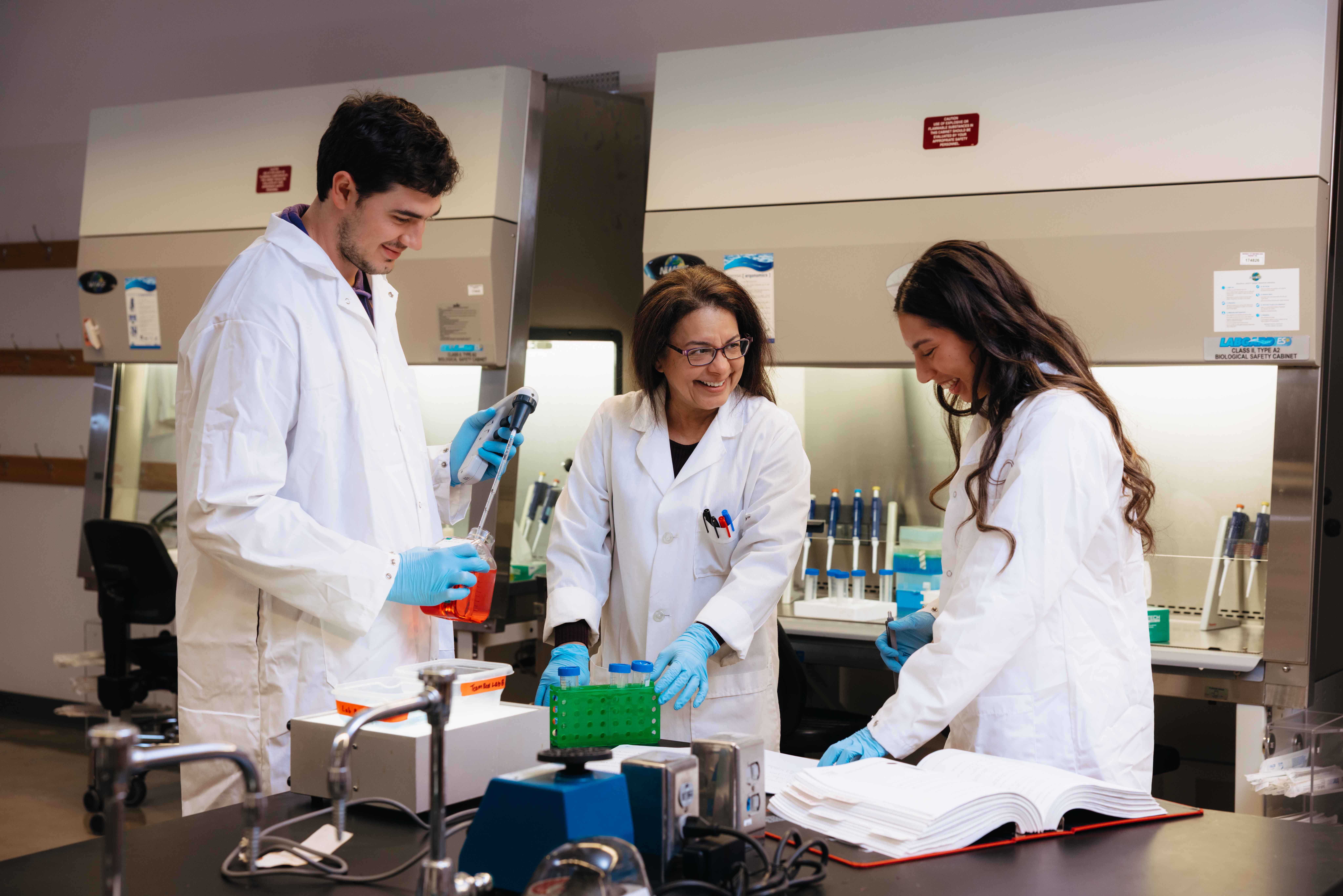 Students working with professor on research in lab