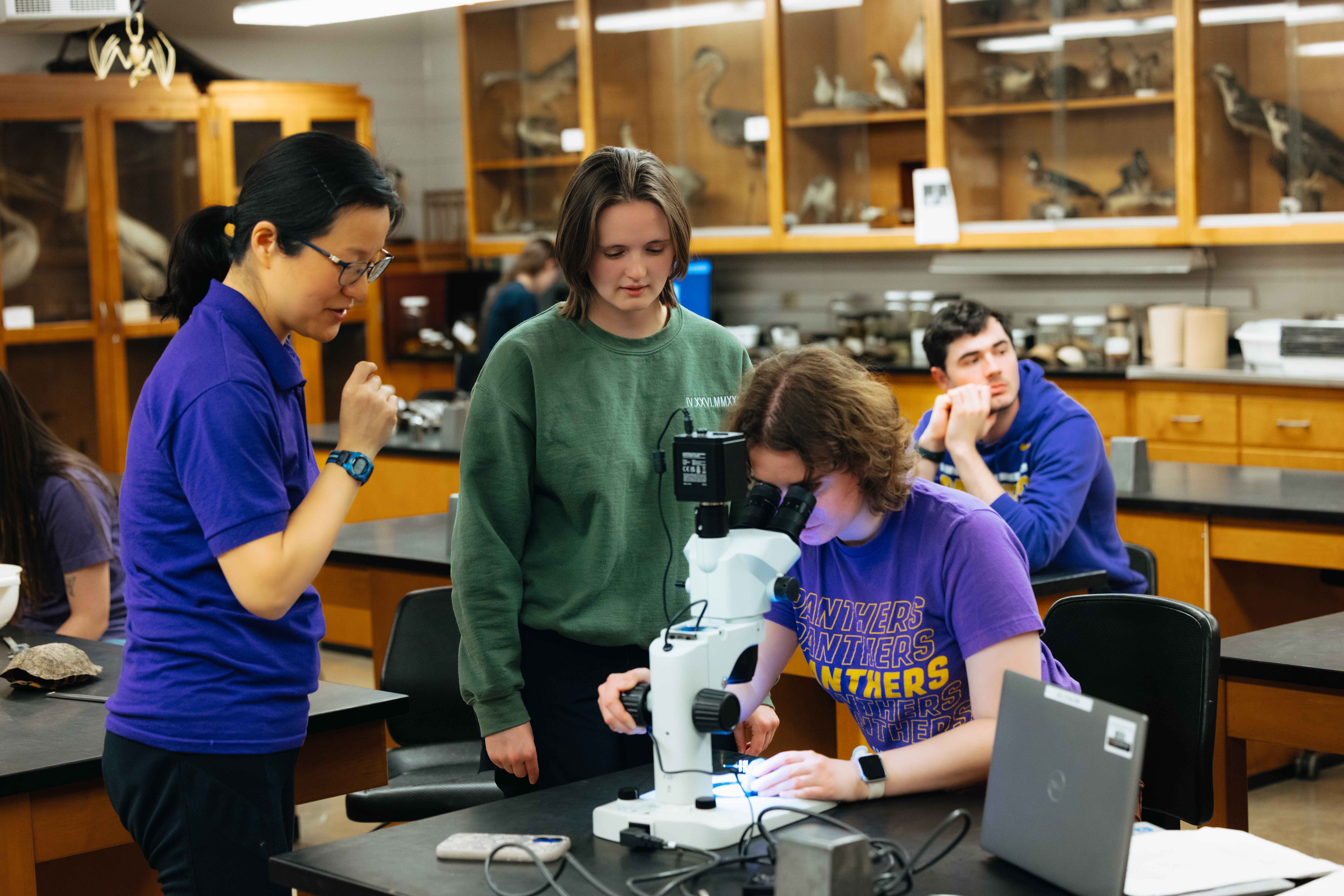 Students working on research with microscope