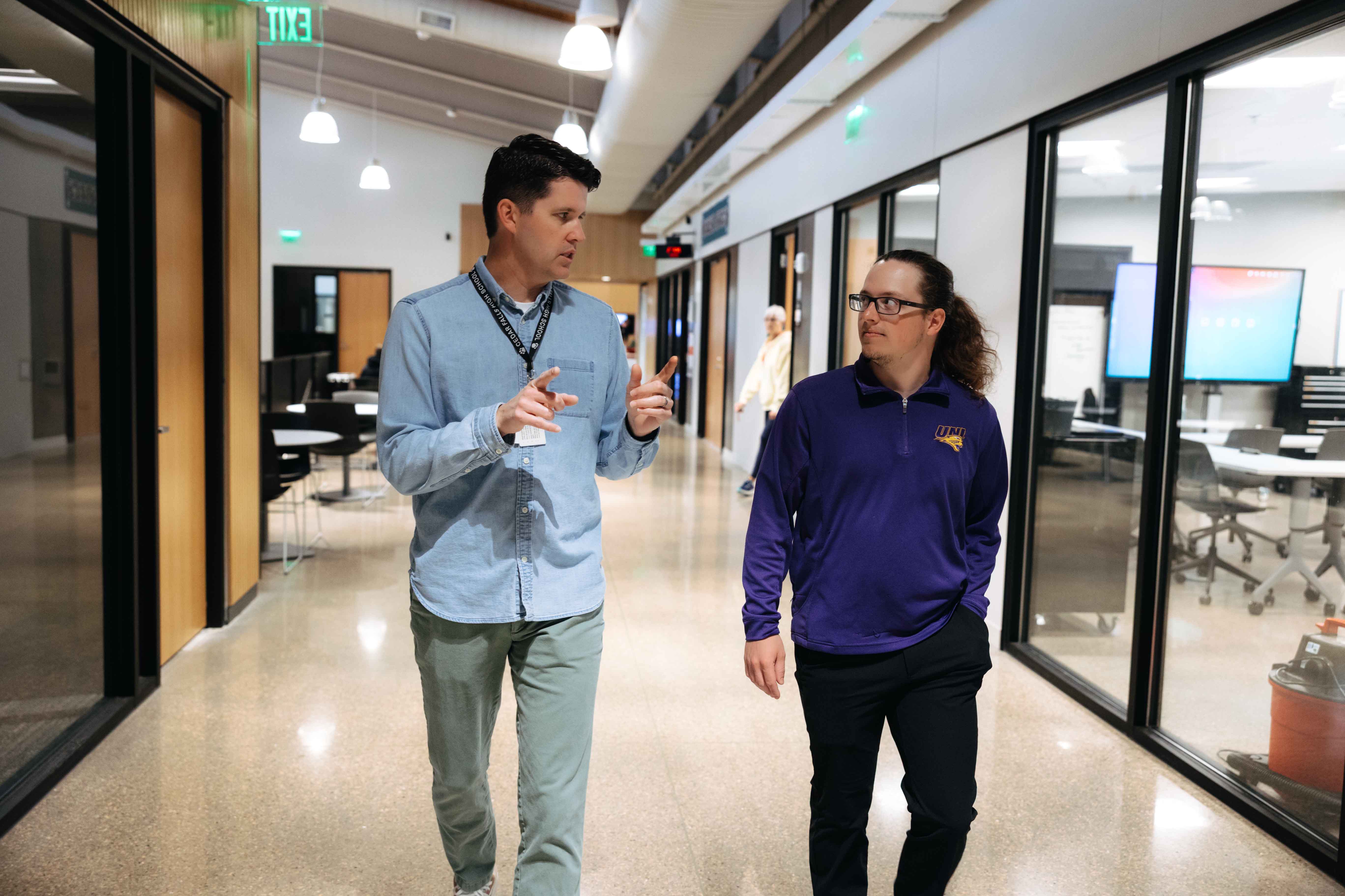 Student and mentor walking down hallway talking