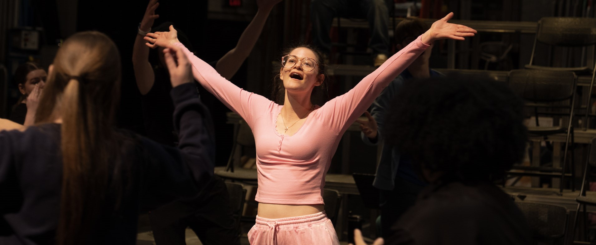 A student with arms thrown wide, rehearsing for Natasha, Pierre and the great comet of 1812