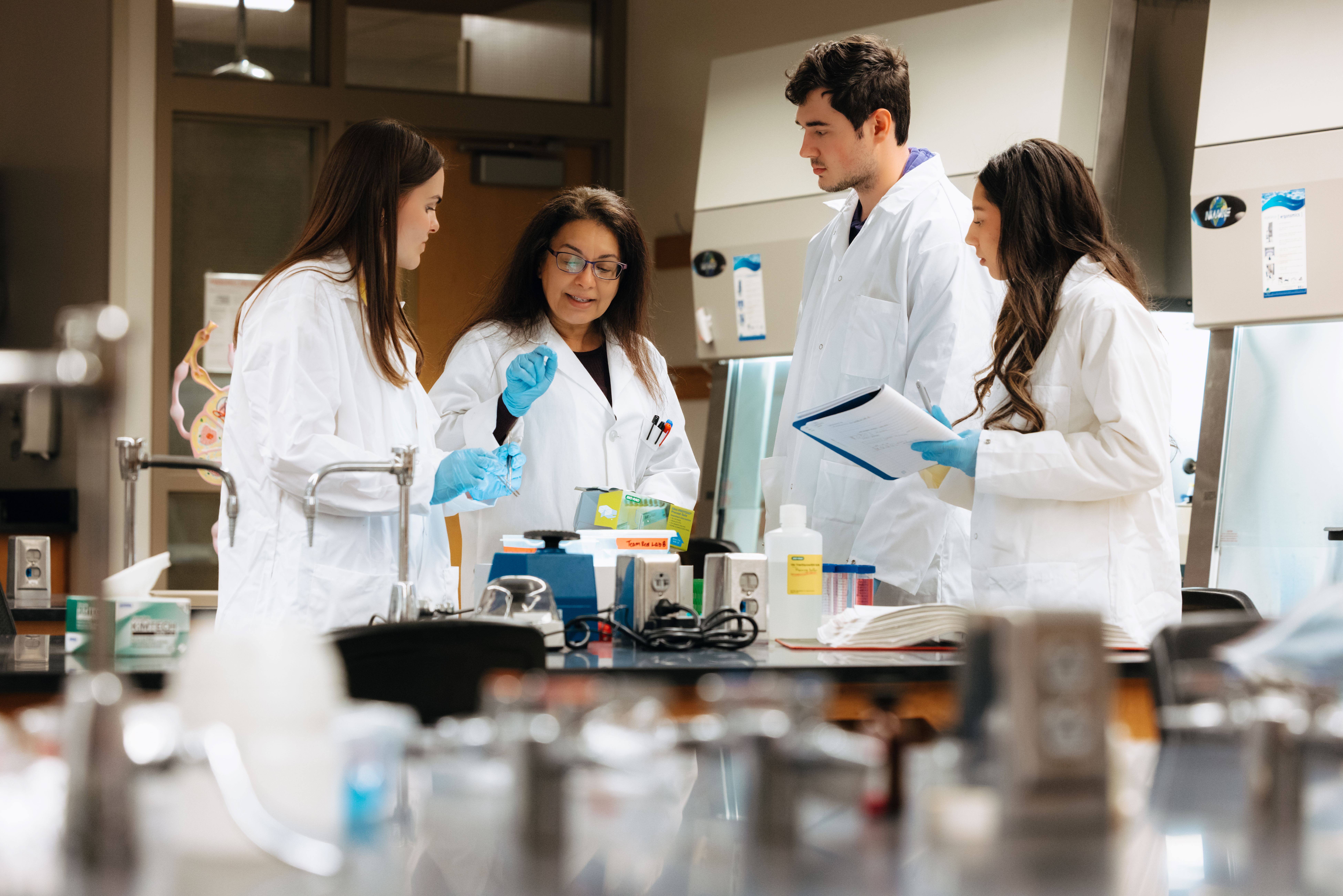 Professor and three students in microbiology lab 
