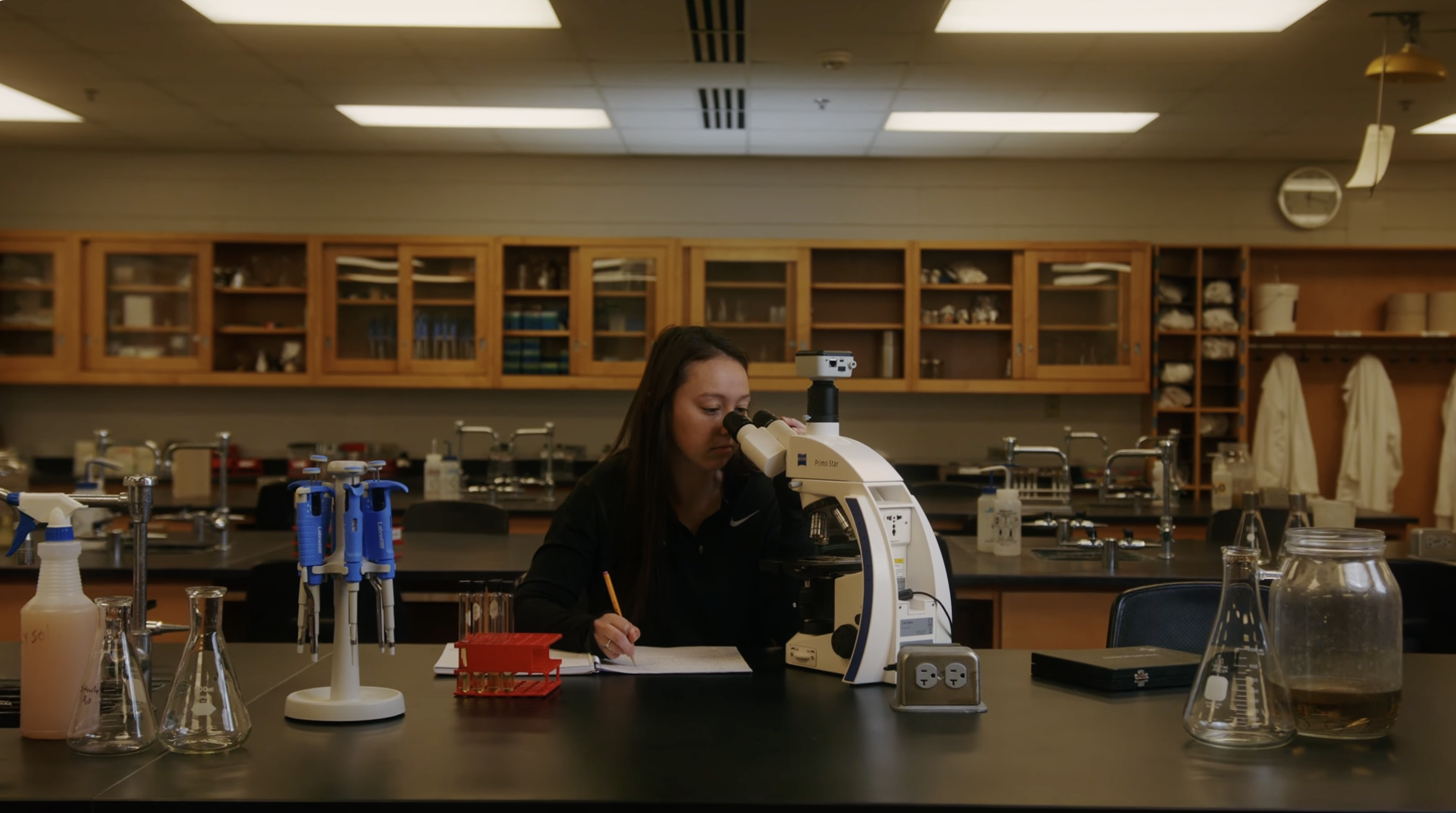 A student looking at a microscope