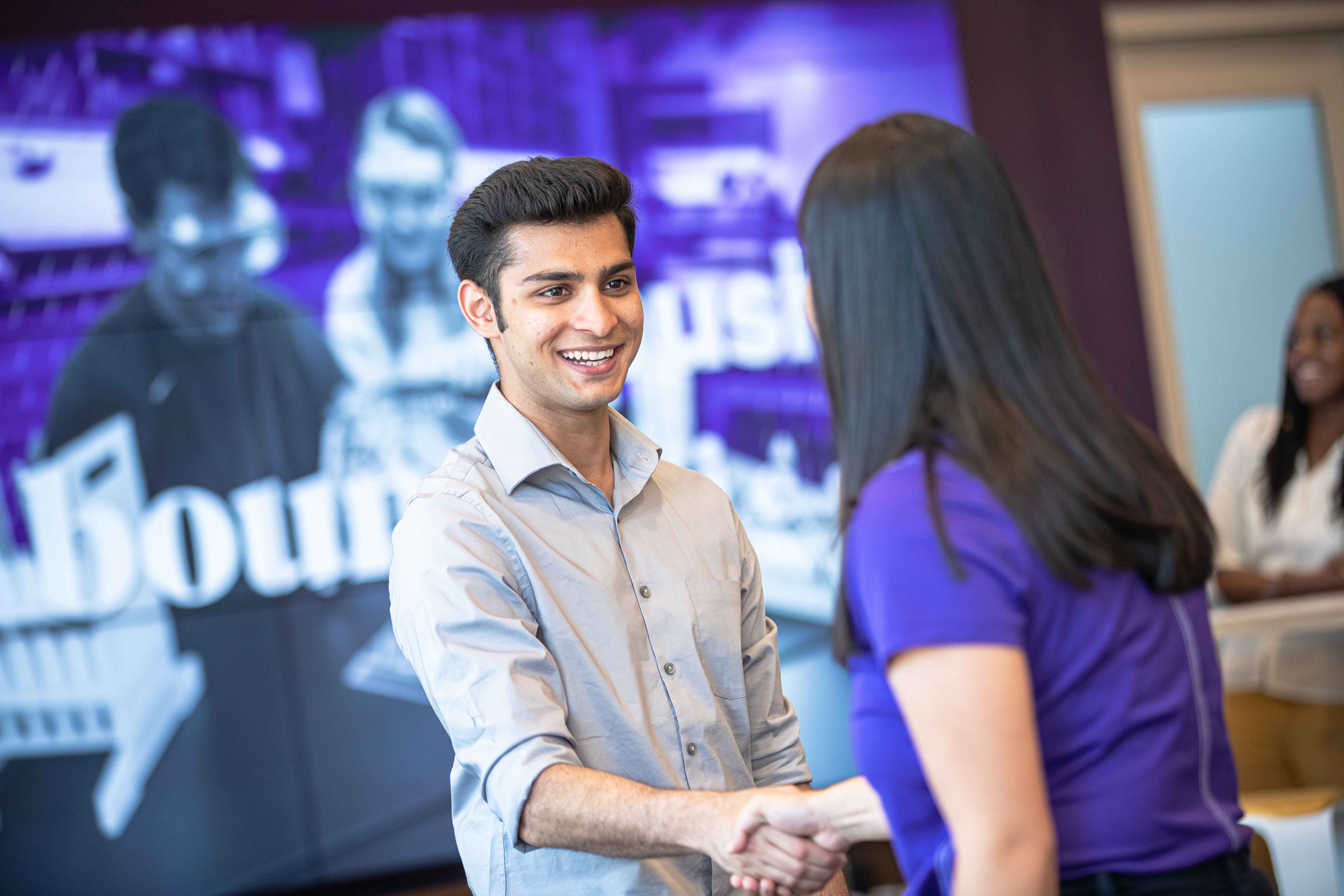 Student shaking hands with professor 