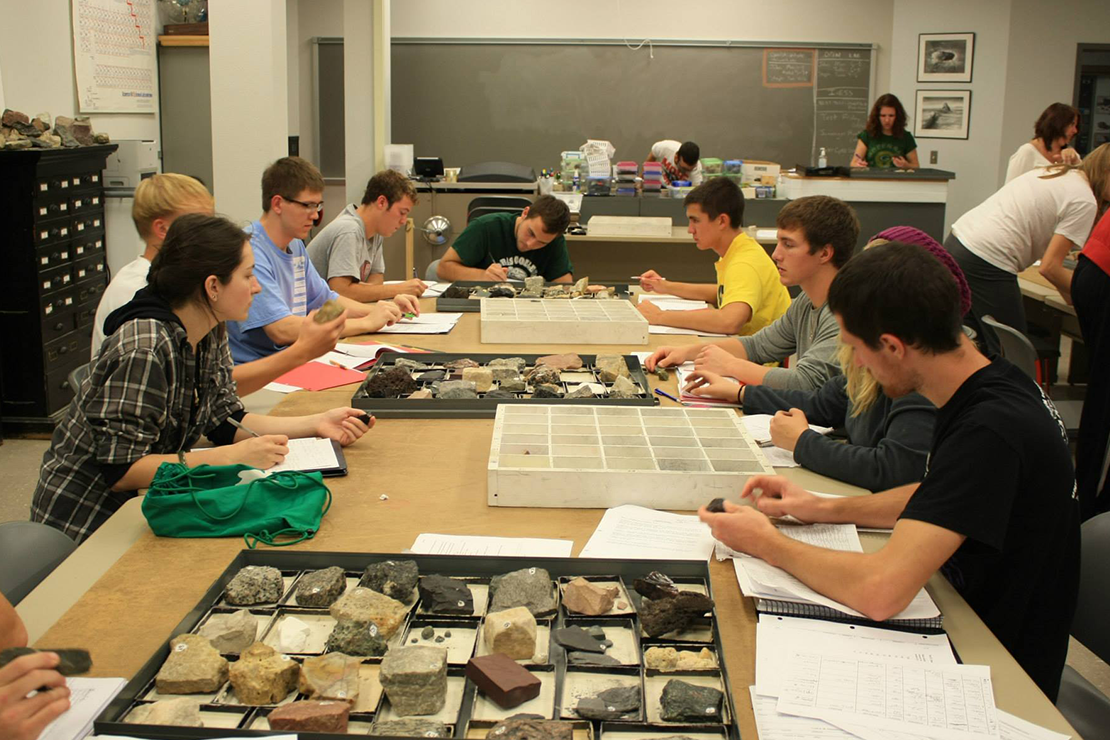 students at a table looking at fossils