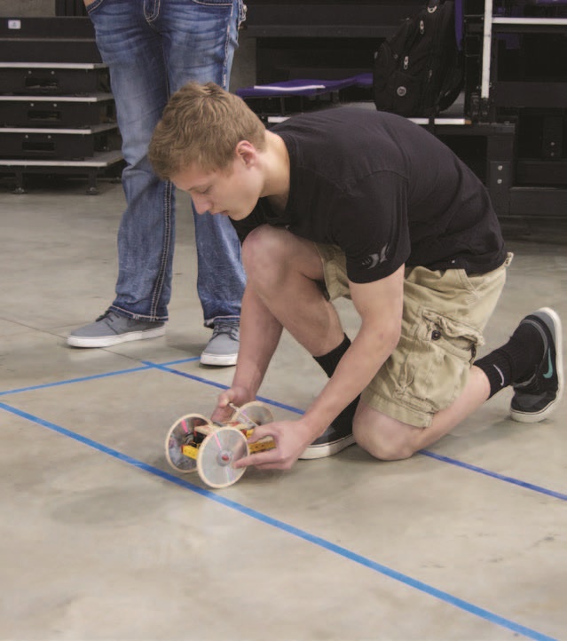 Student with mousetrap car as part of a physics competition event