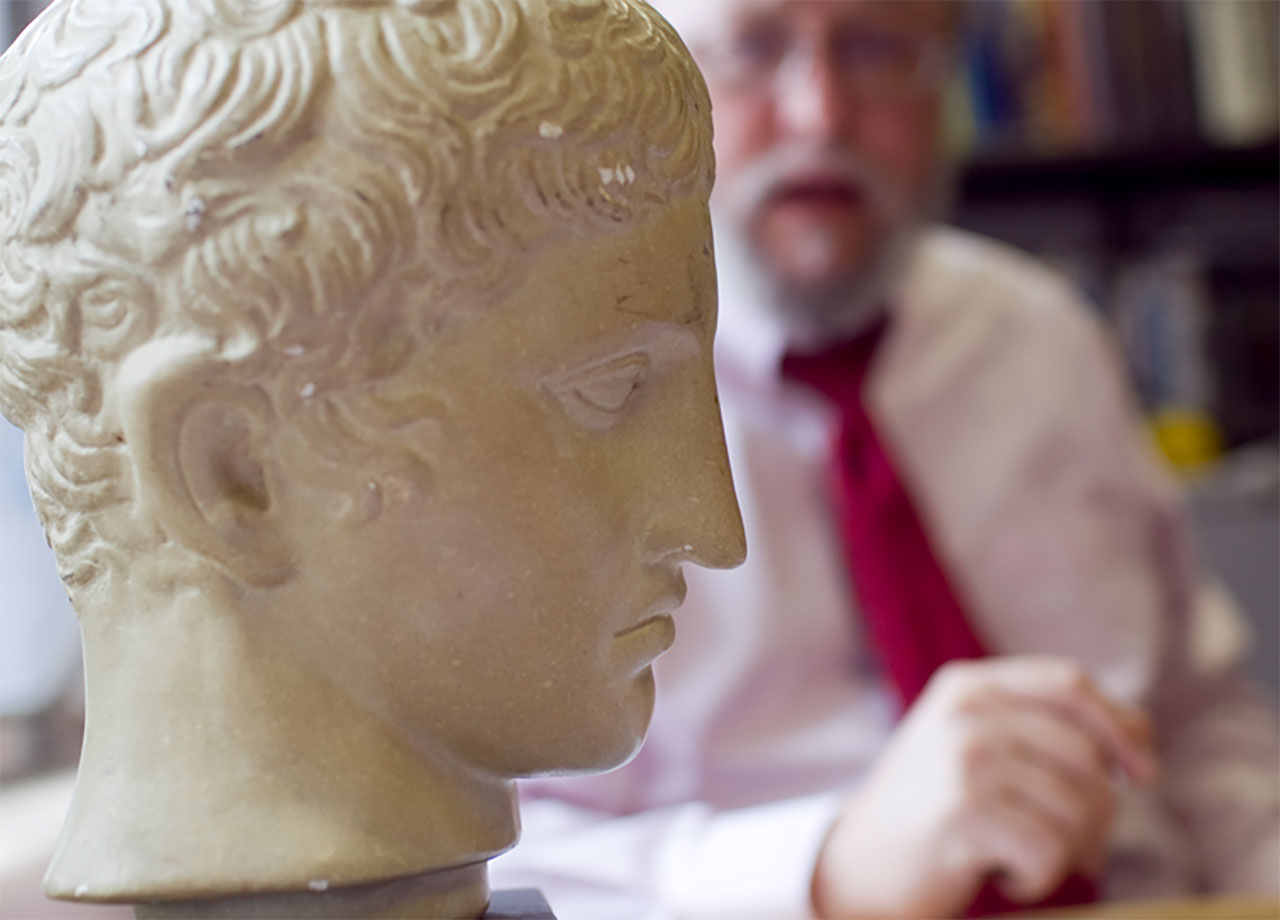 Bust of Greek philosophers with an instructor in the background.