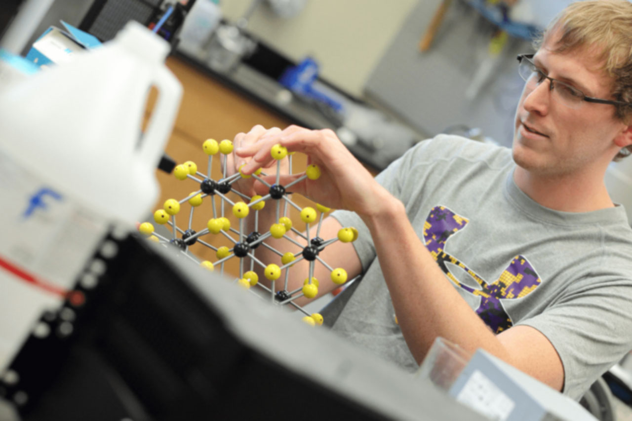 Student adjusting a model molecule.