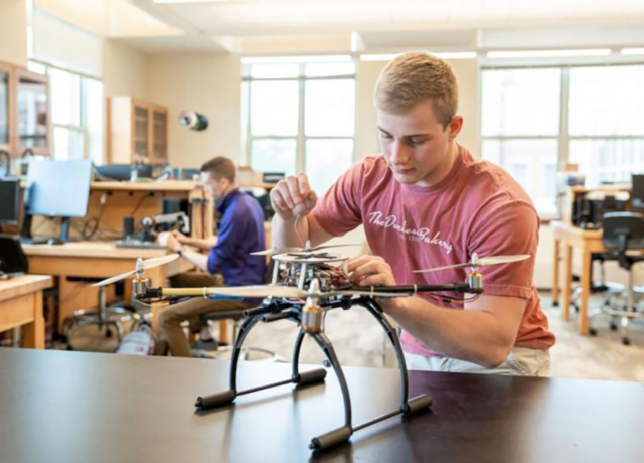 Student inspecting a drone.