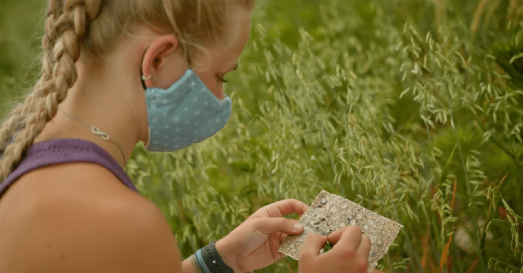 Girl in a field looking at a map