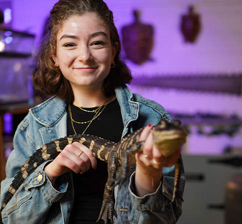 student holding an alligator