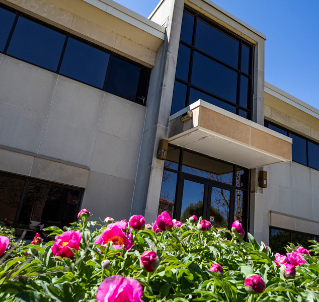 latham hall shown behind some blooming pink flowers
