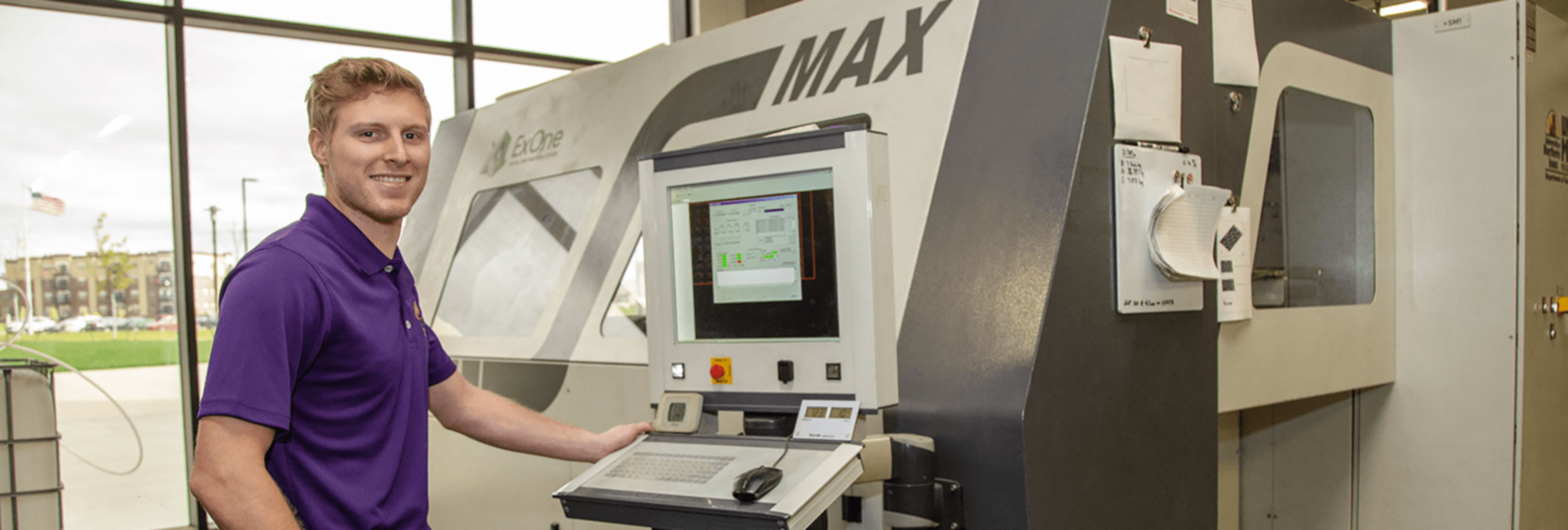 Student standing next to a MAX machine.