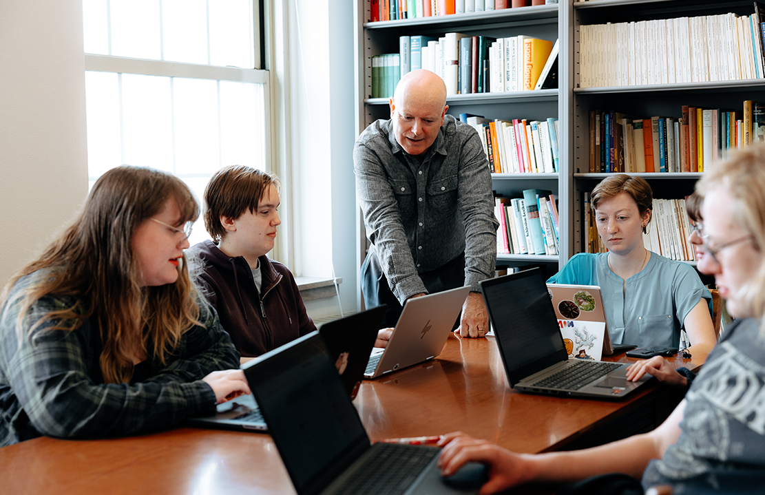 students and professor talking in classroom 