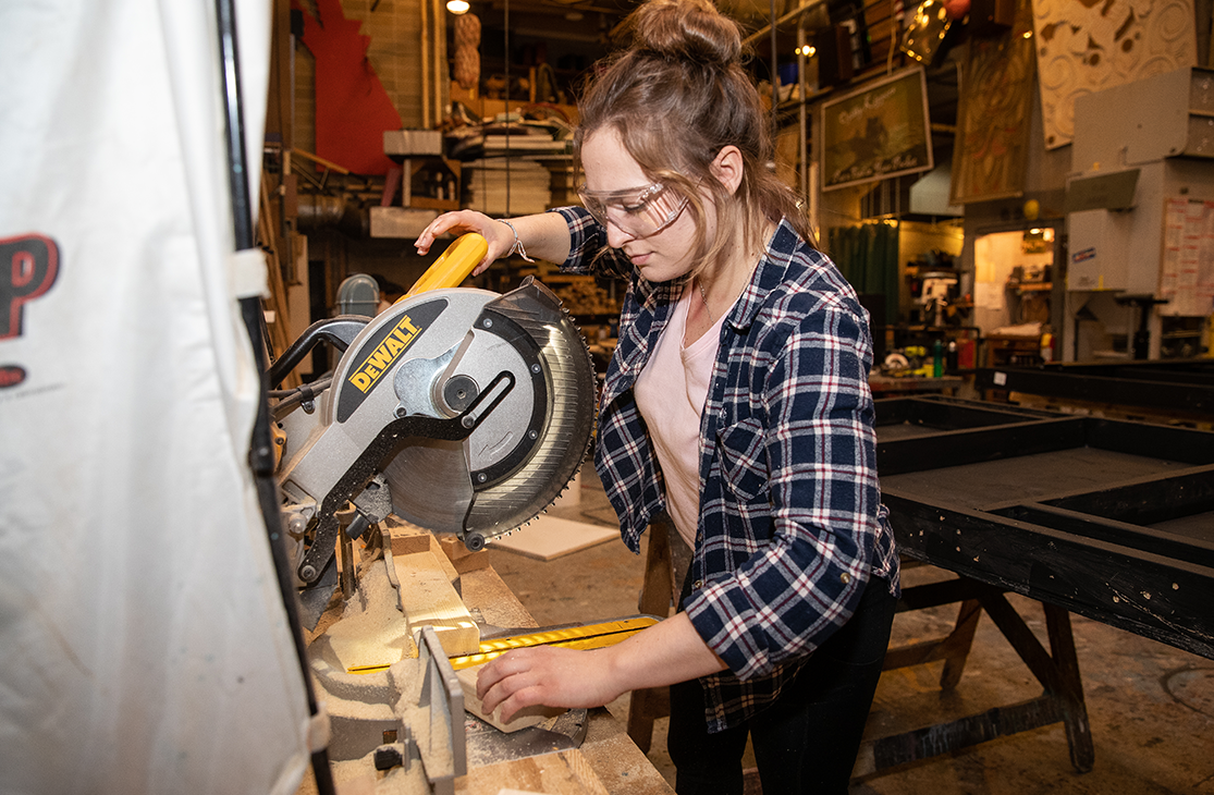 a student operating a miter saw