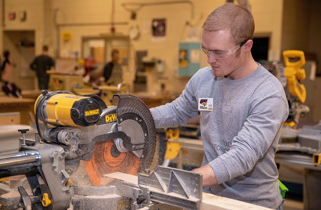 Student operating a circular saw.