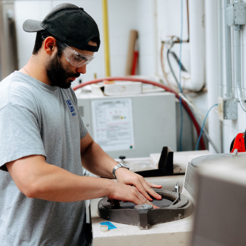 Student using grinding tool to study materials science in Applied Engineering Building
